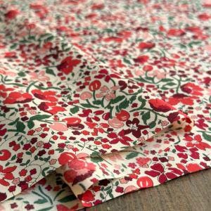 a close-up view of a fabric with a floral pattern in shades of red and green.