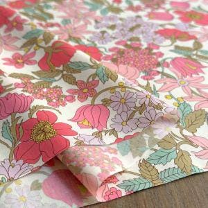 a close-up view of a fabric with a floral pattern, featuring various pink, purple, and green flowers and leaves.