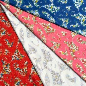 a collection of fabric swatches with various floral patterns, including red, blue, and white designs.
