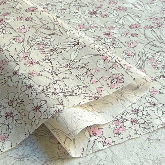 a close-up view of a fabric with a floral pattern, featuring various shades of pink and white flowers.