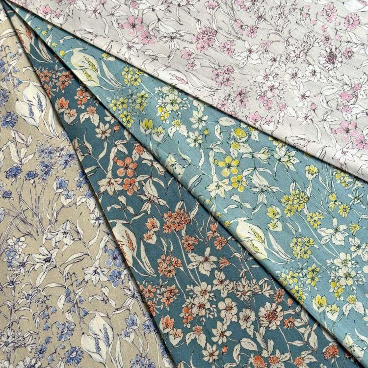 a collection of fabric swatches with various floral patterns, including blue, green, and pink flowers.