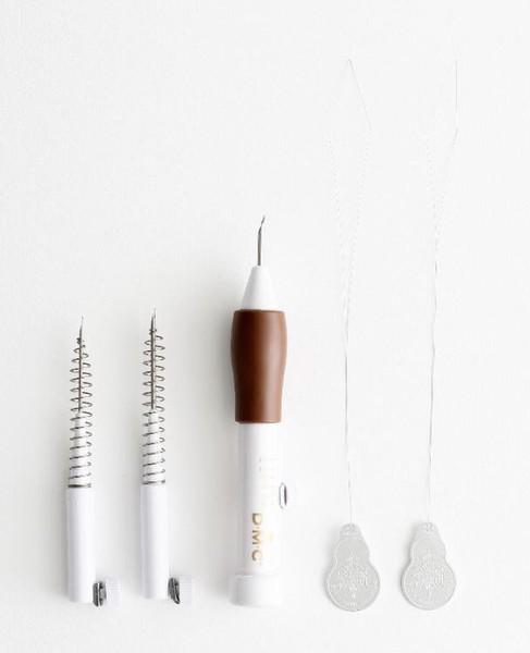 a collection of sewing and crafting tools, including a brown and white sewing machine, a pair of white needles, and two silver earrings.