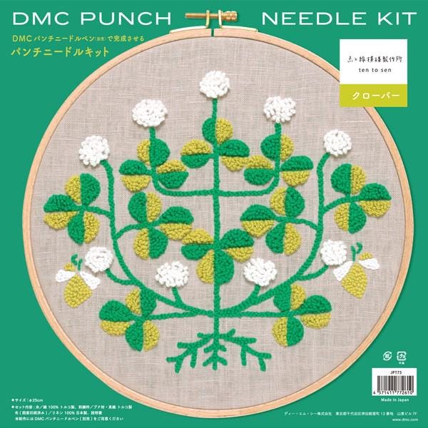 The image is a detailed embroidery pattern featuring a tree with green leaves and white flowers, set against a beige background.
