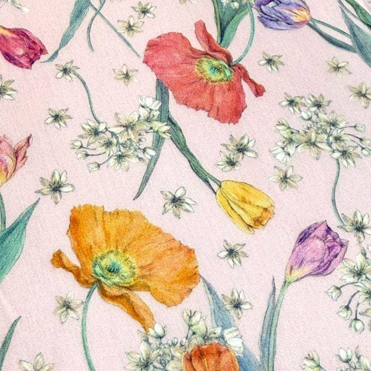 a close-up view of a fabric with a floral pattern. The pattern consists of various flowers, including red poppies, yellow tulips, and purple tulips, along with white flowers. The flowers are arranged in a way that creates a visually appealing and colorful design on the fabric.