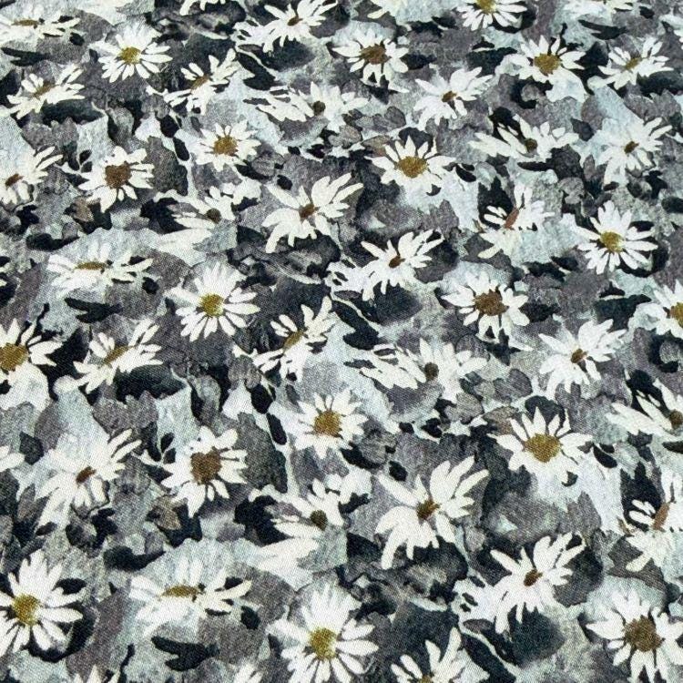 The image is a close-up of a fabric with a repeating pattern of white and gray flowers.
