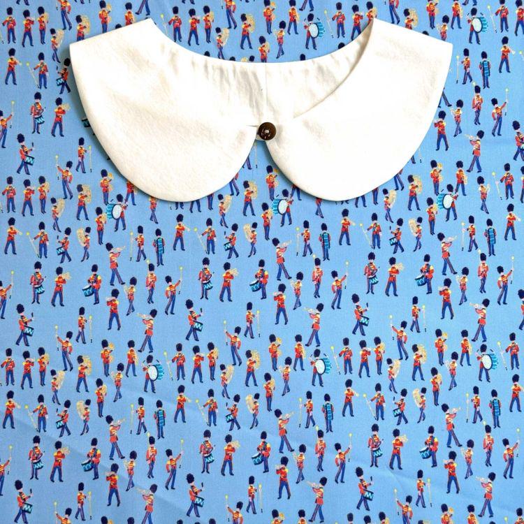 a white collar with a button, set against a background of a repeating pattern of people playing musical instruments, creating a lively and dynamic visual composition.