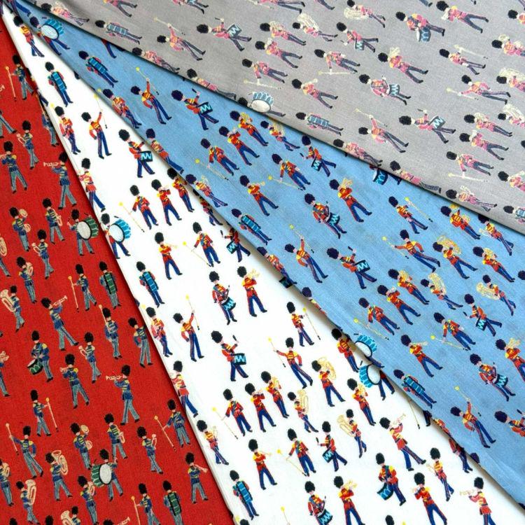 a collection of fabric swatches with various patterns and designs, including marching band motifs and other colorful patterns.