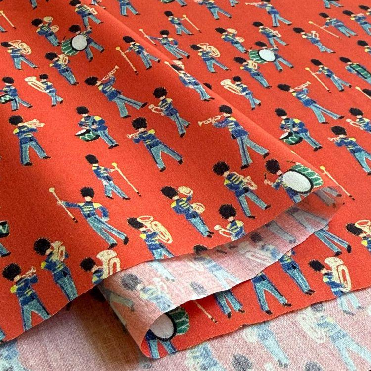 a repeating pattern of people playing musical instruments, such as drums and brass instruments, on a red background.