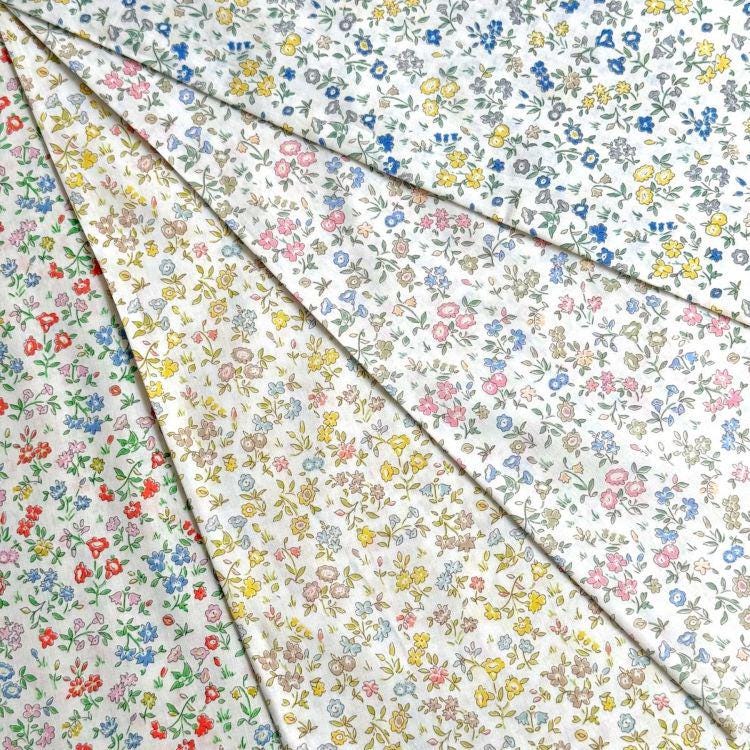 a collection of fabric swatches with various floral patterns, including white, blue, and yellow designs.