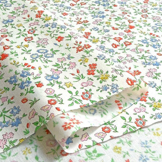 a close-up view of a fabric with a floral pattern, featuring various colors and shapes of flowers and leaves.