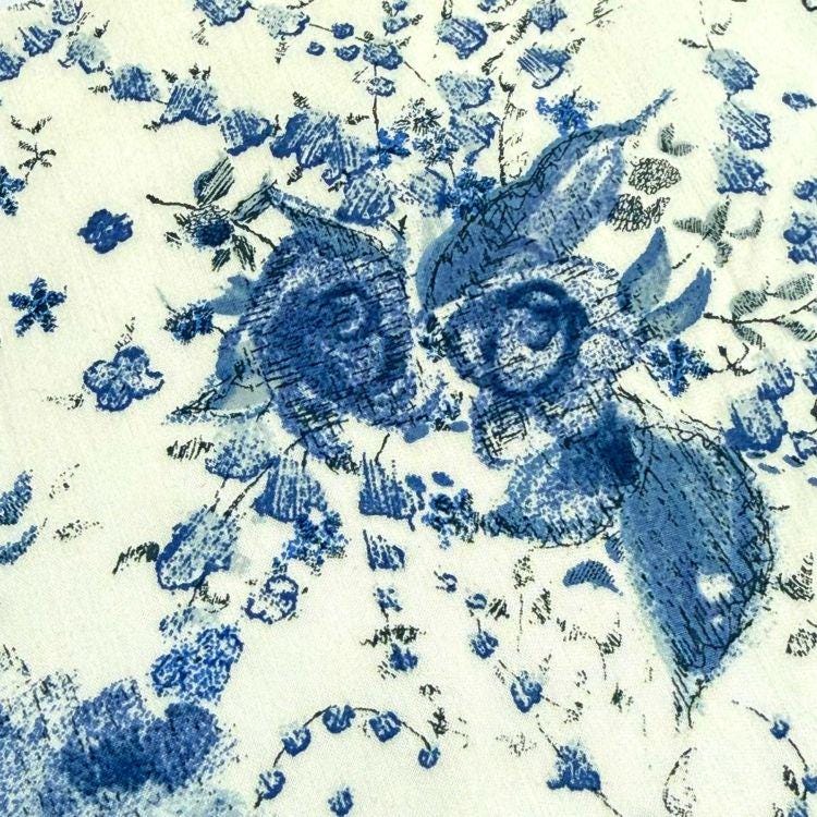The image is a close-up of a blue and white floral pattern, featuring two stylized rabbit heads with intricate details and a sense of movement.