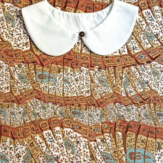 a close-up view of a white collar and a colorful, patterned fabric with a repeating design.