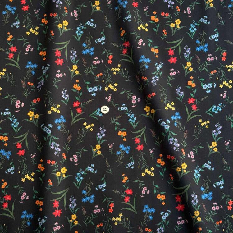 a black fabric with a vibrant floral pattern of various colorful flowers and leaves.