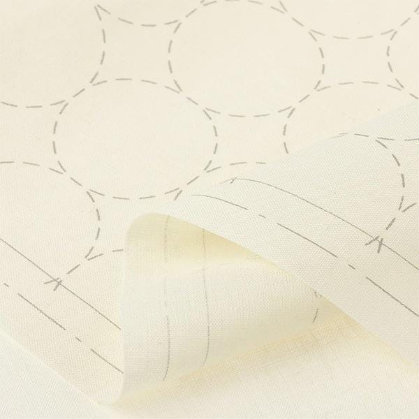 a close-up view of a fabric with a repeating pattern of circles and lines, creating a textured and visually interesting design.