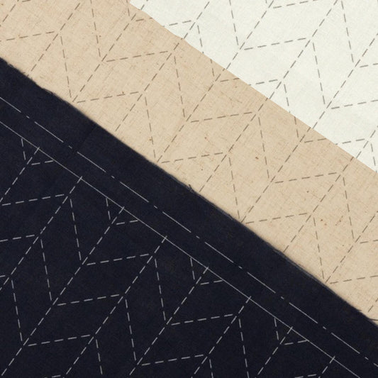 a close-up view of a fabric with a geometric pattern, consisting of three distinct sections: black, beige, and white. The black section has a diagonal pattern, the beige section has a horizontal pattern, and the white section has a zigzag pattern.