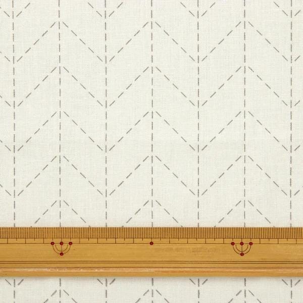 a close-up view of a fabric with a zigzag pattern, and a ruler is placed in front of it, indicating the size or measurement of the fabric.