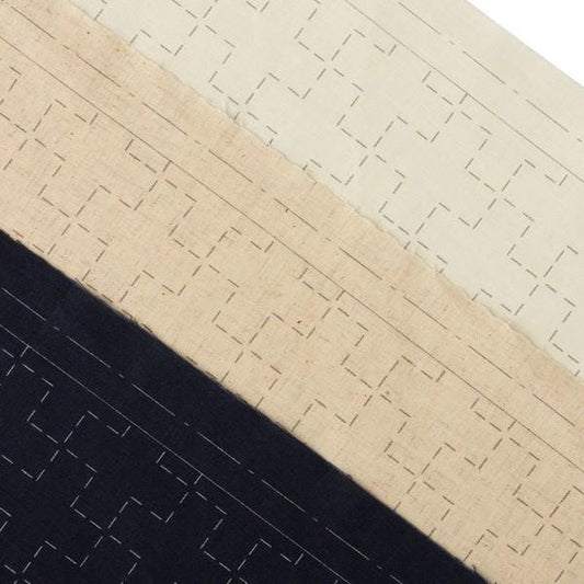 The image is a close-up of a fabric with a repeating pattern of squares and lines, with varying shades of beige and black.
