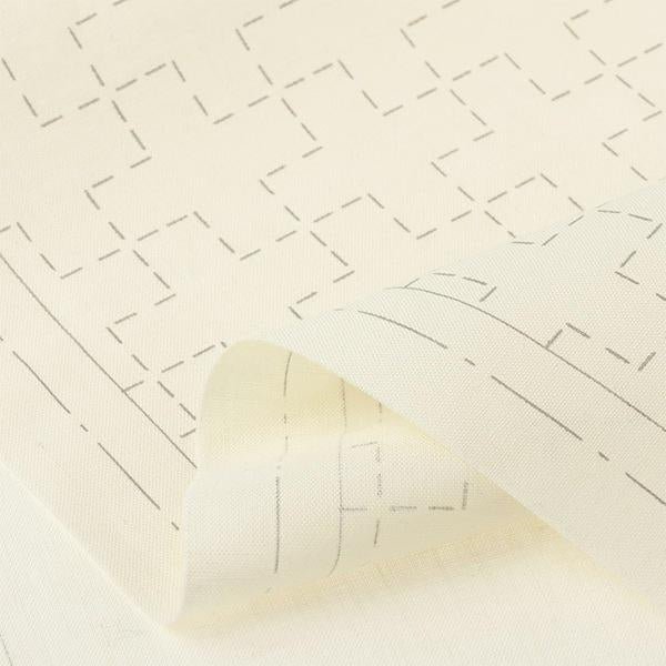 a close-up view of a piece of fabric with a repeating pattern of black lines and dots, creating a geometric design.