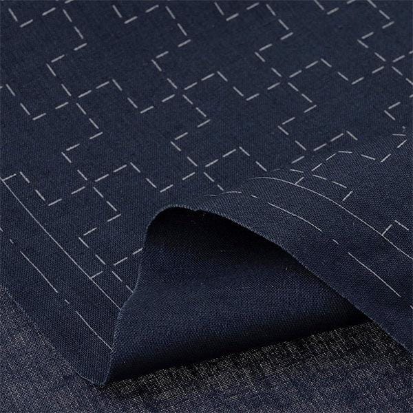 a close-up view of a dark blue fabric with a repeating pattern of white lines or dots, creating a visually striking contrast.