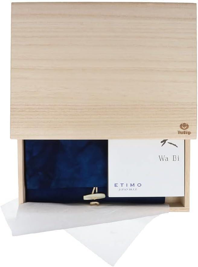 a wooden box with a blue fabric inside, and a white card or label with text on it.