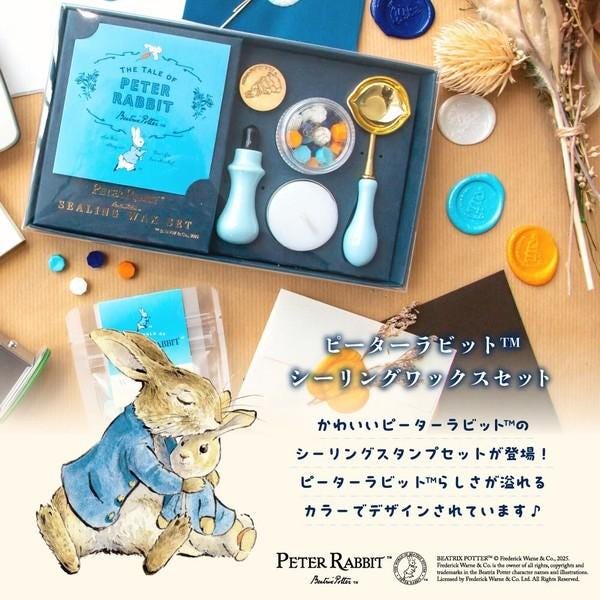 a collection of Peter Rabbit-themed items, including a book, a pen, and various stationery items, all arranged on a table.