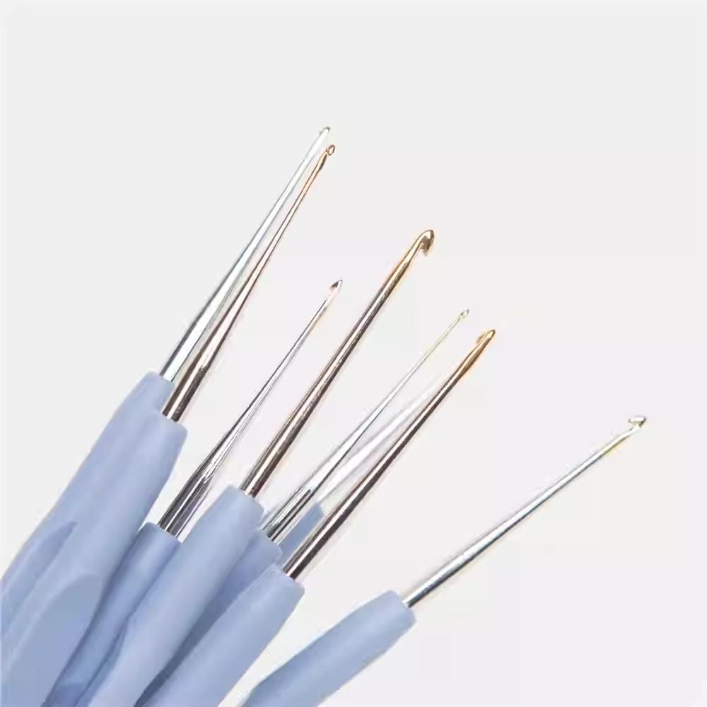 A group of crochet hooks in various sizes and colors, including silver, gold, and blue, arranged against a white background.