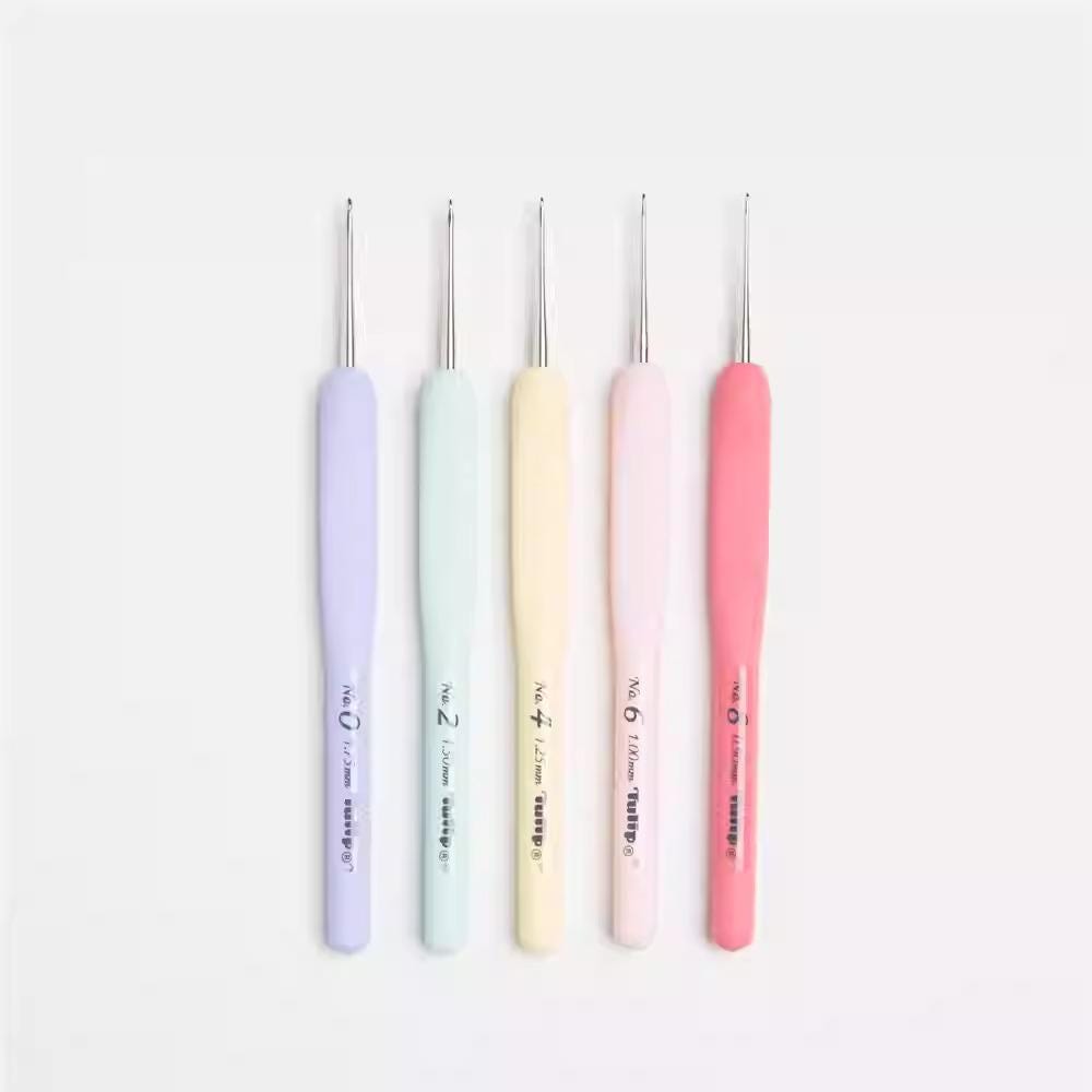 five crochet hooks in various pastel colors, including purple, light blue, light green, light pink, and light yellow.