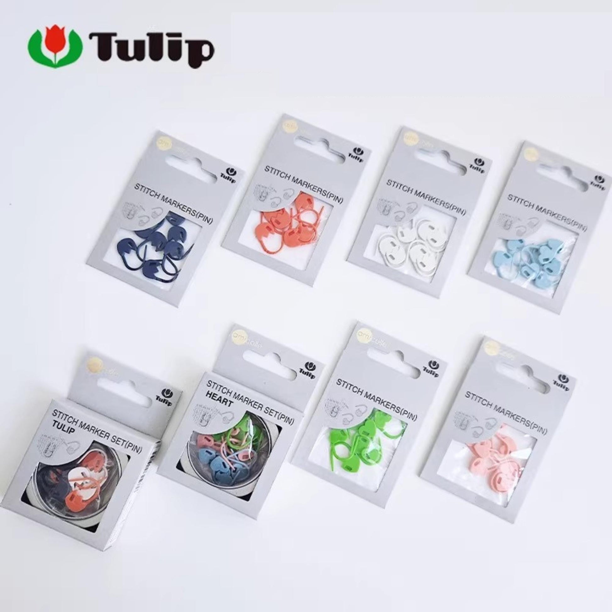 A collection of eight packages of sewing thread markers, each with a different color and pattern, arranged on a white background.