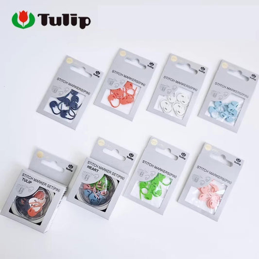 A collection of eight packages of sewing thread markers, each with a different color and pattern, arranged on a white background.