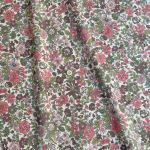 a close-up view of a fabric with a floral pattern, featuring a variety of colors including red, green, and brown.