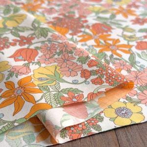 a vibrant floral pattern with various types of flowers and leaves, including orange, yellow, and pink colors. The pattern appears to be a close-up view of a fabric or textile with a floral design.