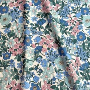 a close-up view of a fabric with a floral pattern in shades of blue, pink, and green. The pattern is composed of various flowers and leaves, creating a vibrant and colorful design.