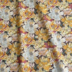 a close-up view of a fabric with a repeating pattern of yellow and white flowers. The flowers are arranged in a way that creates a visually appealing and intricate design.