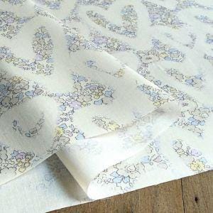 a close-up view of a fabric with a floral pattern, featuring a mix of blue, white, and yellow colors.