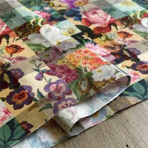 The image is a close-up of a fabric with a vibrant floral pattern, featuring a variety of colorful flowers and leaves.