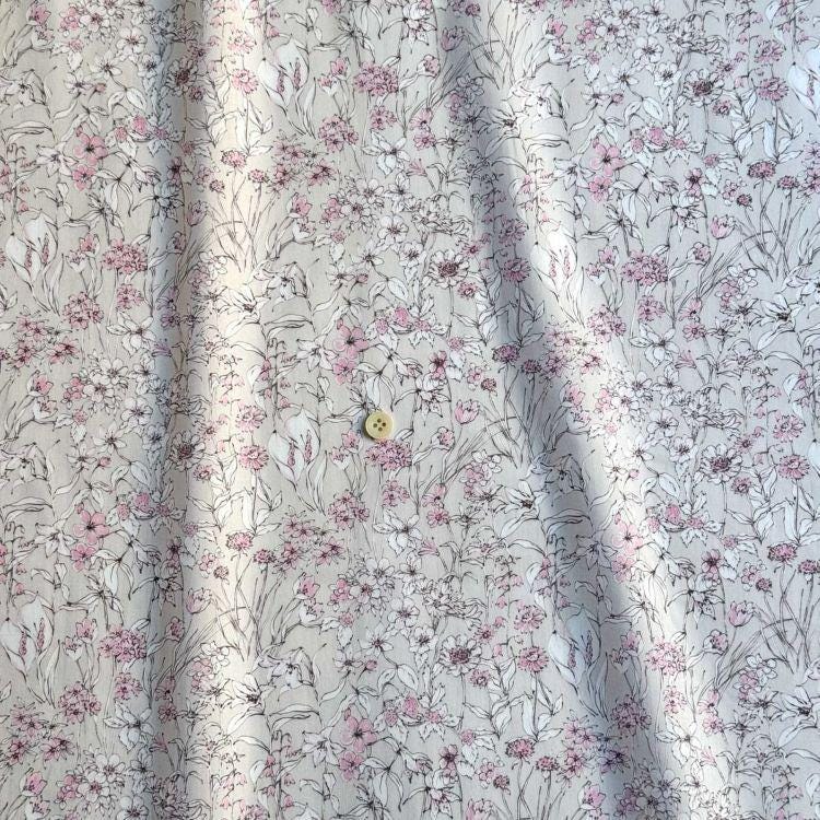 a close-up view of a fabric with a floral pattern, featuring a small button in the center.