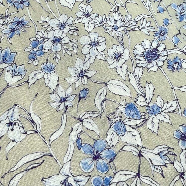 a close-up view of a fabric with a floral pattern. The pattern consists of various blue flowers and leaves, creating a visually appealing and intricate design. The flowers are scattered across the fabric, with some overlapping each other and others standing alone. The leaves are also present, adding to the overall aesthetic of the fabric. The image does not contain any text or other discernible objects, and the focus is solely on the floral pattern.