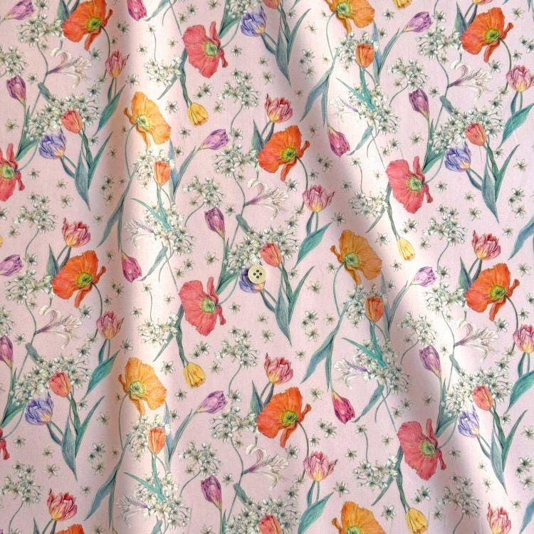 a repeating pattern of colorful flowers and leaves on a light pink background.