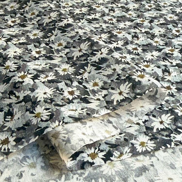 a close-up view of a fabric with a black and white floral pattern.