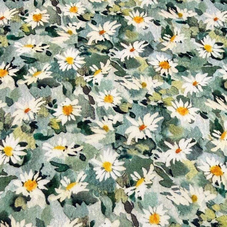 The image is a close-up of a fabric with a pattern of white and green flowers, including daisies, against a green background.