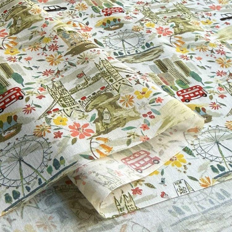 a close-up view of a fabric with a vibrant, colorful pattern of various landmarks and symbols, including London landmarks such as Big Ben, the London Eye, and the London Bridge, as well as other iconic symbols and objects.