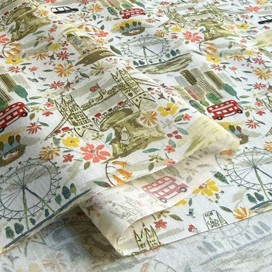 a close-up view of a fabric with a vibrant, colorful pattern of various landmarks and symbols, including London landmarks such as Big Ben, the London Eye, and the London Bridge, as well as other iconic symbols and objects.
