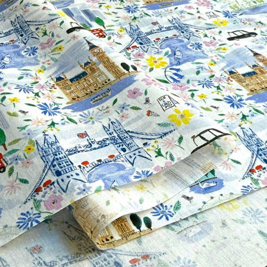 The image is a close-up of a fabric with a floral pattern featuring various landmarks and cityscapes, including London landmarks such as Big Ben, the Tower Bridge, and the Houses of Parliament.