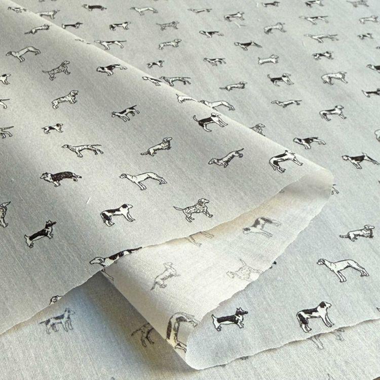 a close-up view of a fabric with a repeating pattern of black and white dog illustrations.