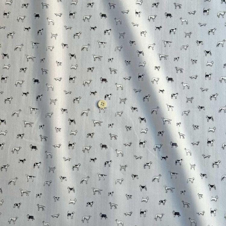 a repeating pattern of black and white dog illustrations on a grey background.