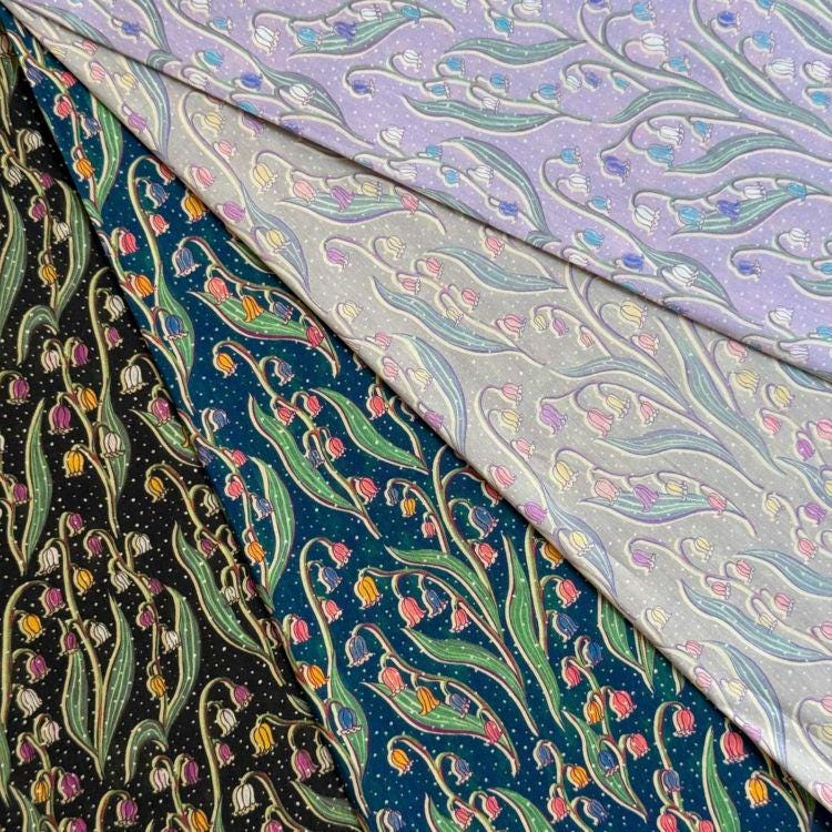 a collection of fabric swatches with various floral patterns, including lily of the valley designs.