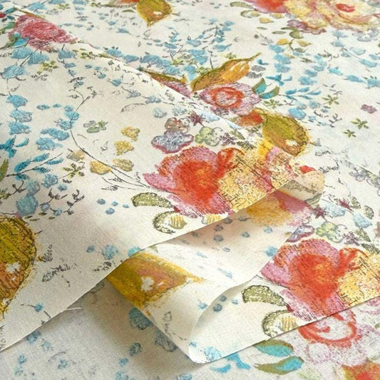a close-up view of a fabric with a floral pattern, including red, yellow, and green flowers. The fabric appears to be folded or crumpled, creating a textured and visually interesting surface.