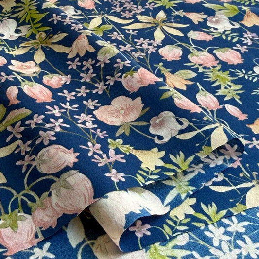 a close-up view of a fabric with a floral pattern in shades of blue and pink. The pattern consists of various flowers and leaves, creating a visually appealing and intricate design.