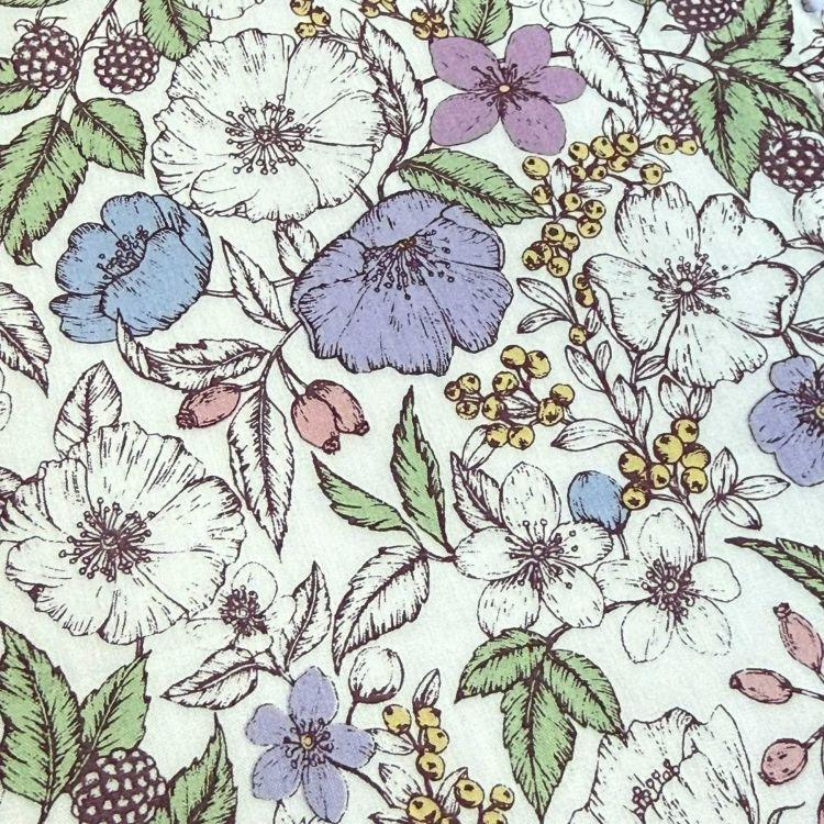 a close-up view of a patterned fabric with a variety of colorful flowers and leaves. The flowers include white, purple, and yellow blooms, along with green leaves and berries. The overall design is visually appealing and vibrant, with the different colors and shapes creating a lively and dynamic pattern.