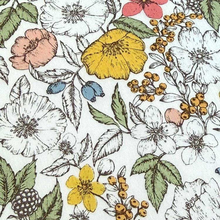 The image is a close-up of a patterned fabric with a variety of colorful flowers and leaves. The flowers include white, pink, yellow, and orange blooms, as well as green leaves and berries. The overall design is visually appealing and vibrant, with the different colors and shapes creating a lively and dynamic pattern.